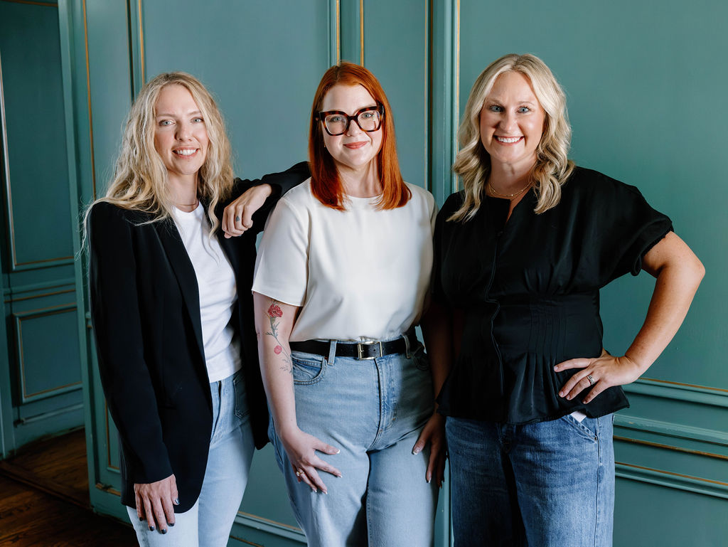 The three sentr. founders standing together in front of a green paneled wall